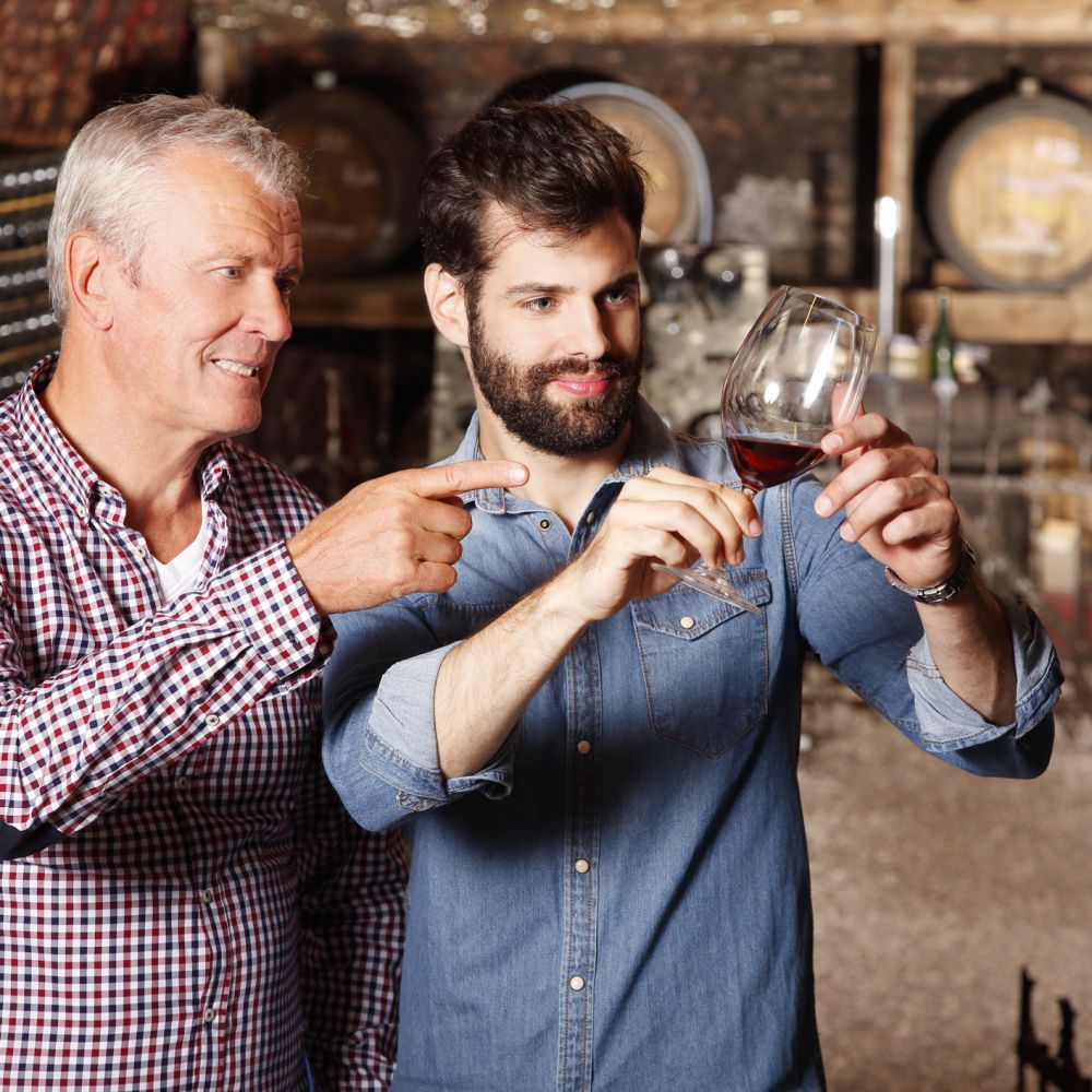 Father and son at winery examine quality of the latest batch