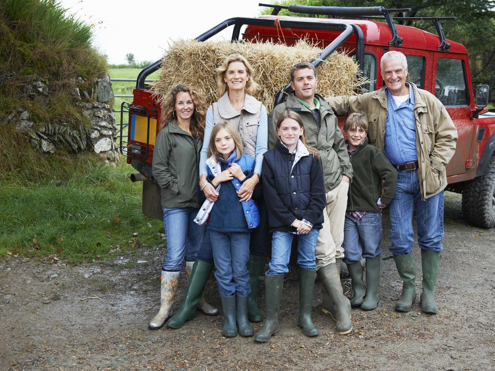 multi-generation farm family standing in front of tractor