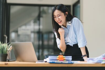 young business woman looks at computer, excited about results